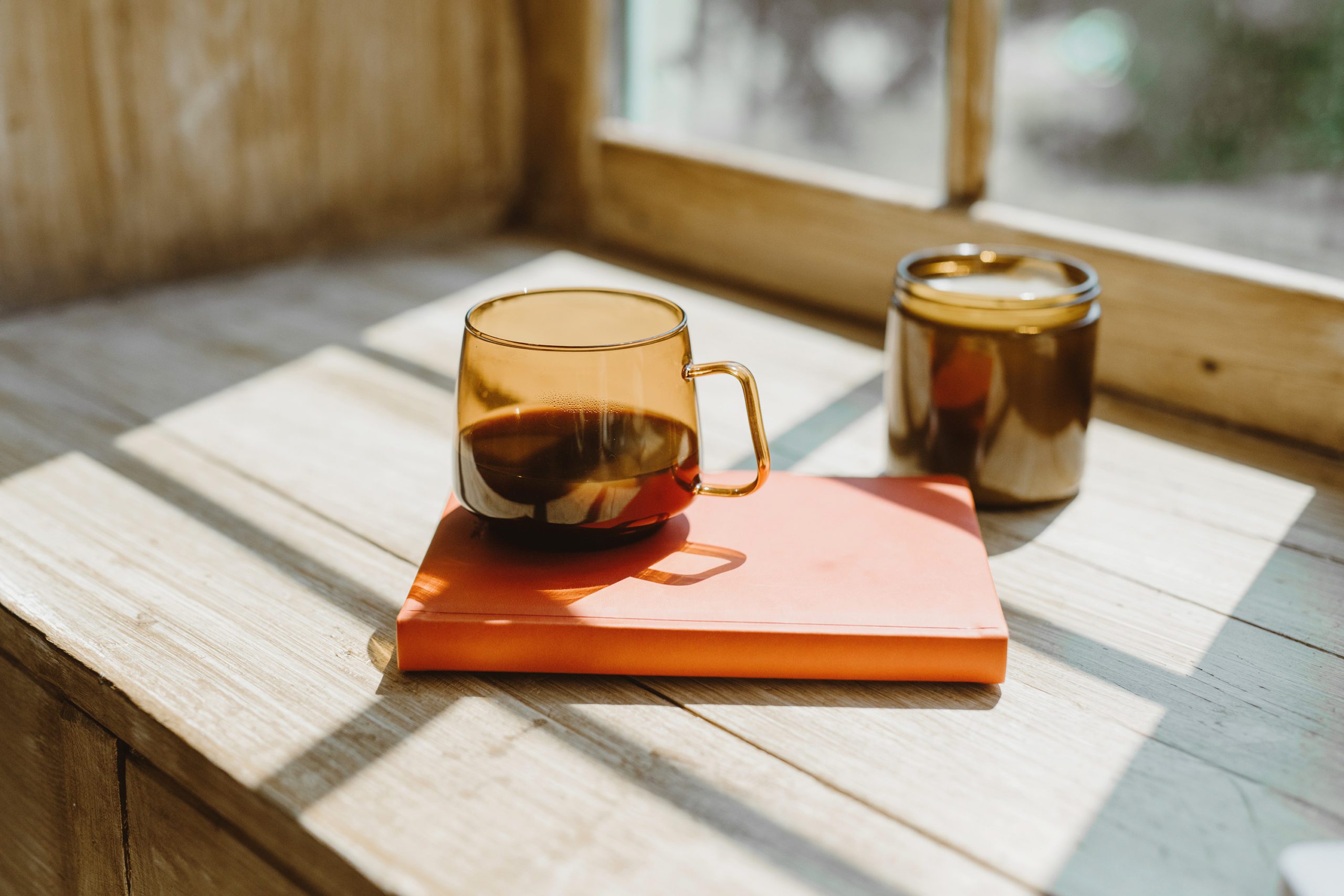 Amber coffee mug on a sunny window frame.